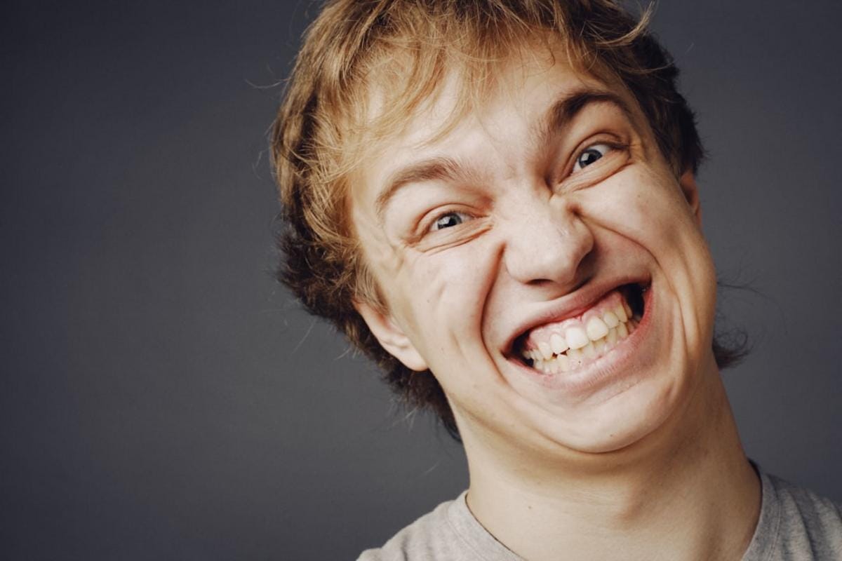 A funny scene of two people laughing awkwardly after a blunder at a social gathering, illustrating humor easing social tension